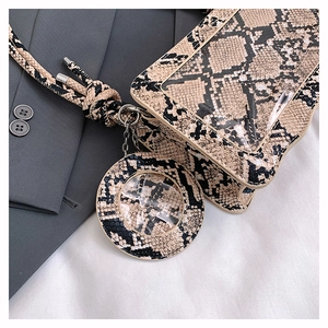 Close-up of snake print square bag with clear PVC window and knotted rope shoulder strap