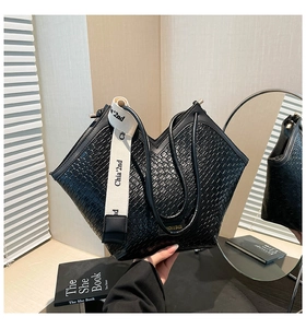 Close-up of black crocodile pattern tote bag with V-shape top and chic fabric strap