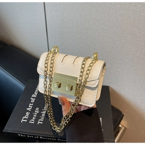 Détail d'un mini sac bandoulière crème avec boucle carrée dorée et bandoulière en chaîne