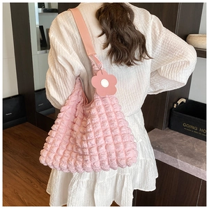 Detail of pink bubble texture fabric on a shoulder bag with matching floral charm