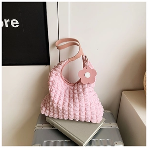Detail of pink bubble texture tote bag with leather strap and cute flower charm accessory