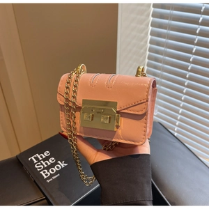 Détail du mini sac rose à chaîne avec fermoir doré et texture en cuir mat élégant
