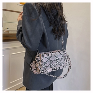 Detail of snake print crossbody bag with wavy bottom and detachable round coin purse