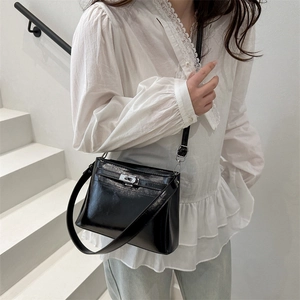 Chic black glossy underarm bag with silver twist lock and wide shoulder strap for women