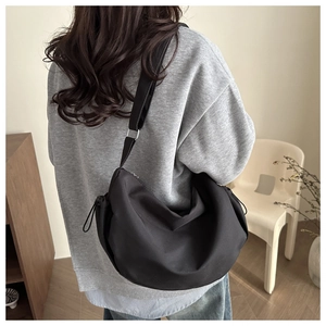 Vue de dos d'un grand sac bandoulière en toile noire style demi-lune tendance