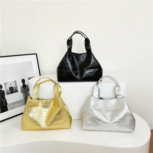 Three crocodile embossed tote bags in black, gold, and silver on white display stands