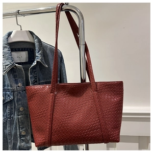 Detail of red woven leather tote bag with Intrecciato pattern for daily commuting