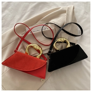 Detail of red and black crossbody bags with artistic irregular gold lava metal handles