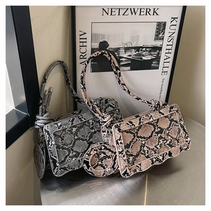 Close-up of snake skin texture and wave-shaped base on luxury grey and brown shoulder bags