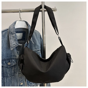 Détail du sac bandoulière croissant en nylon noir avec large sangle et cordon de serrage