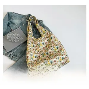 Detail of beige canvas tote bag with 3D cartoon bear and daisy floral patterns