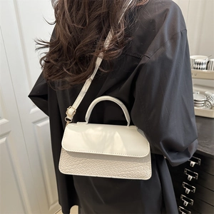 White faux leather crossbody bag with crocodile texture and adjustable shoulder strap