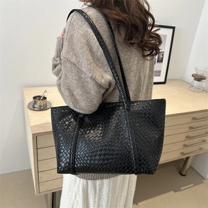 Minimalist large capacity black woven tote bag with smooth texture and long shoulder straps