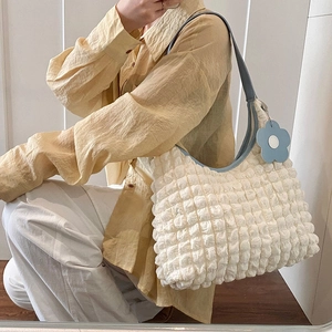 Minimalist white bubble texture tote bag with blue trim and floral charm accessory
