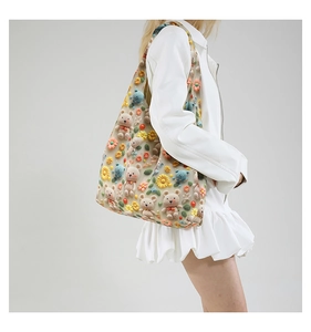 Close-up of beige canvas tote bag with 3D crochet flowers and plush bear ornaments