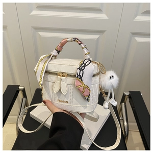 Détail du sac boîte blanc croco avec poignée en soie et breloque en peluche
