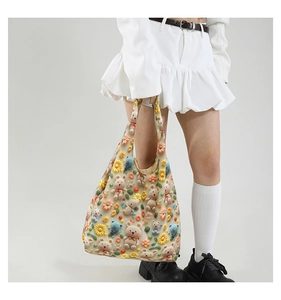 Detailed macro view of 3D plush bears and crochet flowers on the cream cotton tote bag