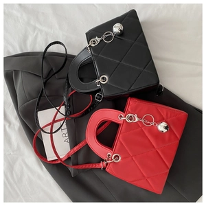 Top view of red and black quilted leather bags with round handles and metal charm detail
