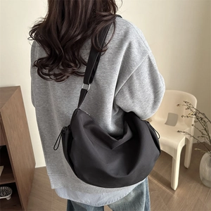 Sac bandoulière noir minimaliste en forme de croissant avec sangle large et cordon