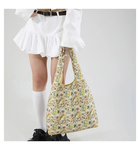 Detailed close-up of 3D plush bear charms and floral appliques on a beige tote bag