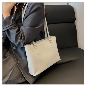 Gros plan d'un cabas en cuir PU blanc avec détails dorés porté par un mannequin pour le bureau