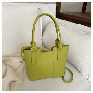 Gros plan d'un sac seau vert fruit avec surpiqûres et détails en métal doré chic