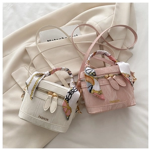 Détail de mini sacs boîte avec poignées en soie et texture marbrée en crème et rose