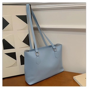 Vue détaillée du cabas bleu clair avec coutures blanches et boucles dorées chic