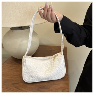 Close-up of woven leather texture on a white hobo bag with gold zipper and matte finish