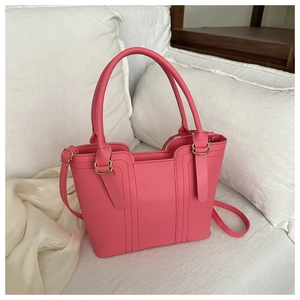 Détail du sac seau rose vif en similicuir avec coutures verticales et finitions dorées