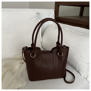 Détail d'un cabas en cuir PU marron foncé avec boucles dorées et bandoulière réglable