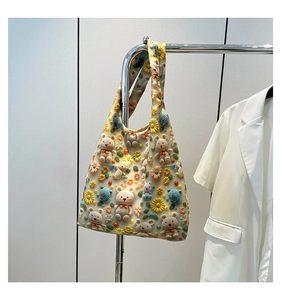 Close-up of handmade 3D crochet bears and floral accents on a beige canvas tote bag