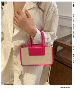 Pink and beige contrast stitching crossbody bag shown on model with a white blazer