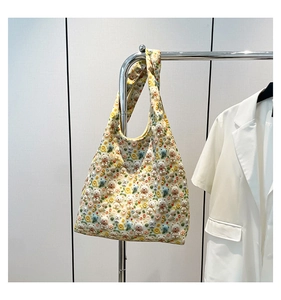 Detail of light yellow tote with colorful floral embroidery and 3D bear plush ornaments