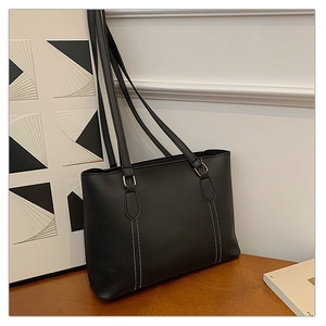 Détail du sac cabas noir avec coutures contrastées blanches et texture mate sobre