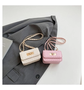 Close-up of quilted mini flap bags in pink and cream with elegant V-stitch and gold chain