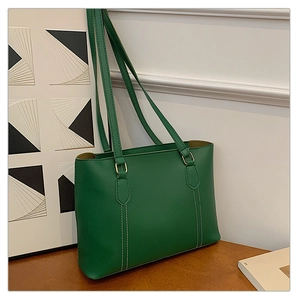 Détail d'un sac cabas vert émeraude avec surpiqûres blanches et fines bandoulières