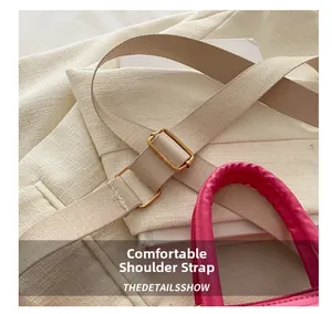 Close-up of comfortable woven strap and golden buckle on pink crossbody bag