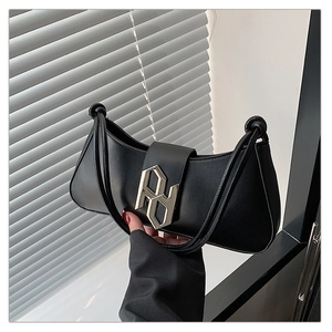 Detailed view of black hobo bag with a silver geometric buckle and soft matte texture