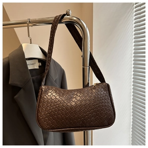 Close-up of dark brown woven shoulder bag featuring premium lattice texture and gold zipper