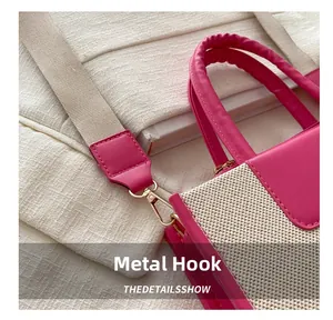 Close-up of the metal hook hardware and durable beige woven strap on the pink handbag