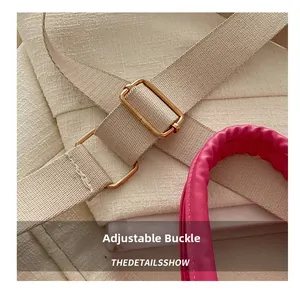 Detail of adjustable gold buckle on beige woven strap with pink pleated handle accent