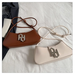 Detail of minimalist leather shoulder bags with silver geometric buckles in brown and beige