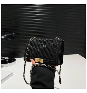 Détail du sac bandoulière noir matelassé avec fermoir doré et bandoulière chaîne