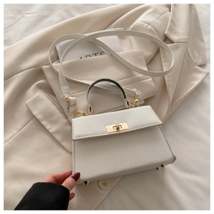 Detail of white lychee pattern handbag with gold hardware lock and bottom studs