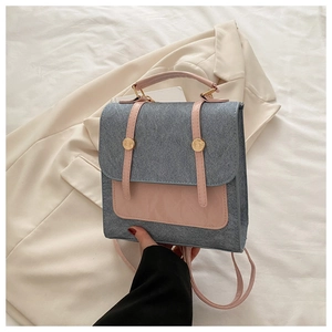 Detailed shot of grey wool texture and pink leather trim with golden buckles on a handbag