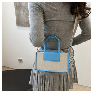 Rear view of model wearing a light blue and beige textured mini crossbody bag