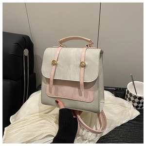 Detail of a two-tone mini backpack with pink flap and gold circular buckle fastening