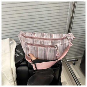 Detailed view of pink striped crossbody waist bag with double zippers and textured fabric