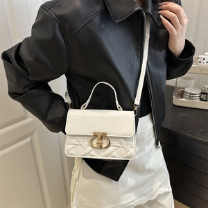 White quilted leather handbag with gold logo clasp worn crossbody by a model